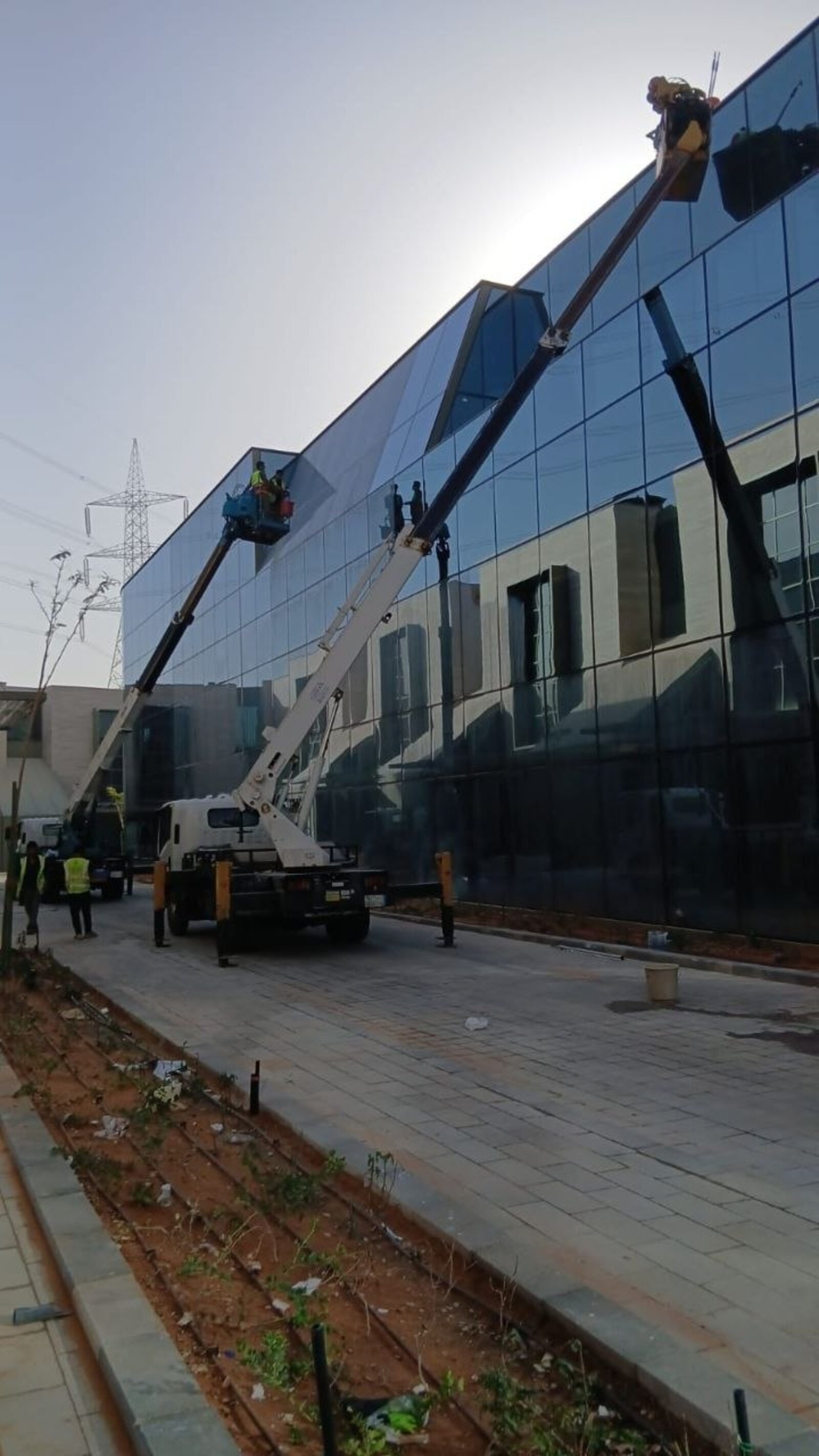 شركة تنظيف واجهات زجاجية بالرياض تنظف واجهة مبنى زجاجي في شمال الرياض برافعتين - حلول وتميز