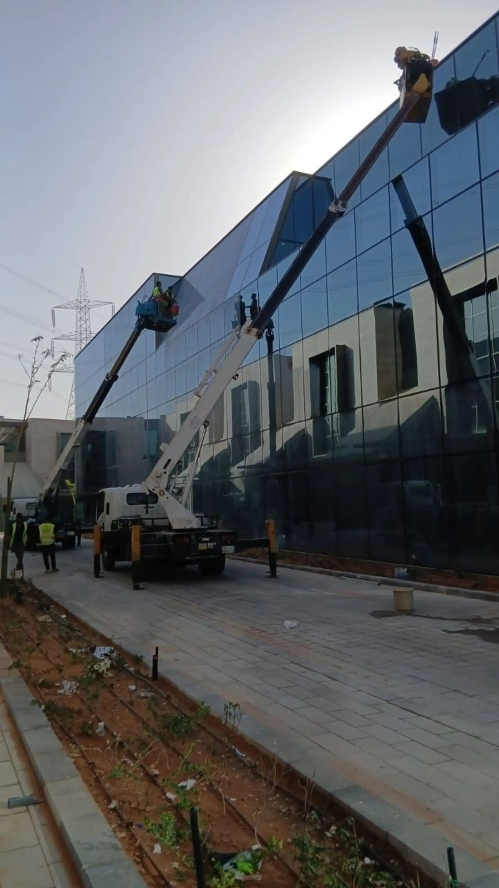 شركة تنظيف واجهات زجاجية بالرياض تنظف واجهة مبنى زجاجي في شمال الرياض برافعتين - حلول وتميز