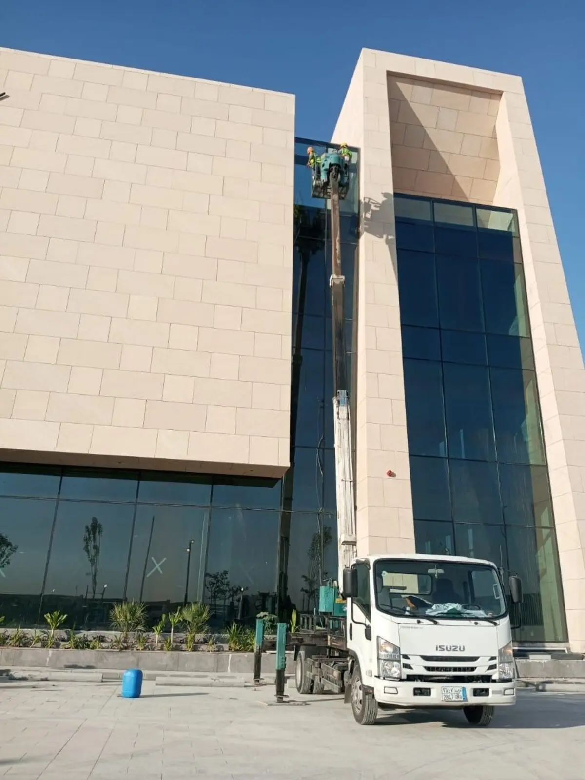 رافعة تابعة لشركة تنظيف واجهات مباني بالرياض تنظف واجهة حجرية زجاجية لمبنى بحي الملك عبدالله