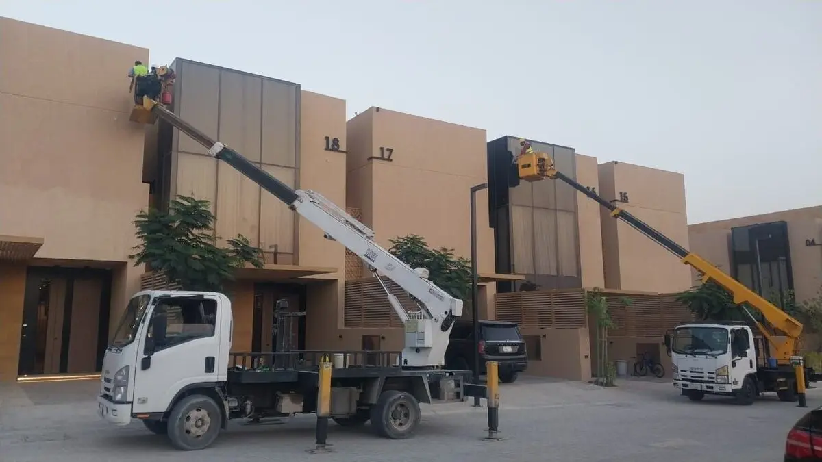 رافعتان تابعتان لشركة تنظيف واجهات مباني بالرياض تنظفان واجهات فلل حديثة في حي الملك عبدالله