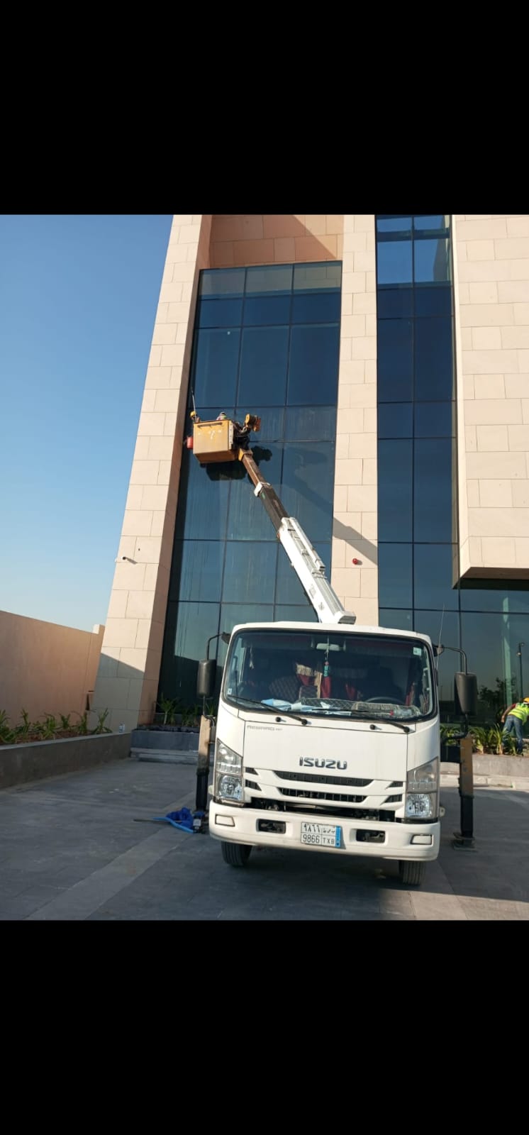 فريق تنظيف واجهات على رافعة لمبنى كلادينج في الرياض