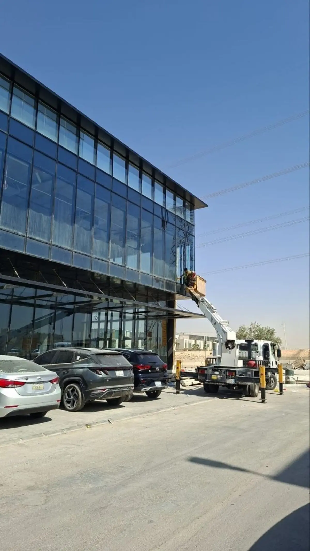 رافعة هيدروليكية تابعة لـ شركة تنظيف واجهات ابراج بالرياض تنظف واجهة زجاجية لمبنى تجاري