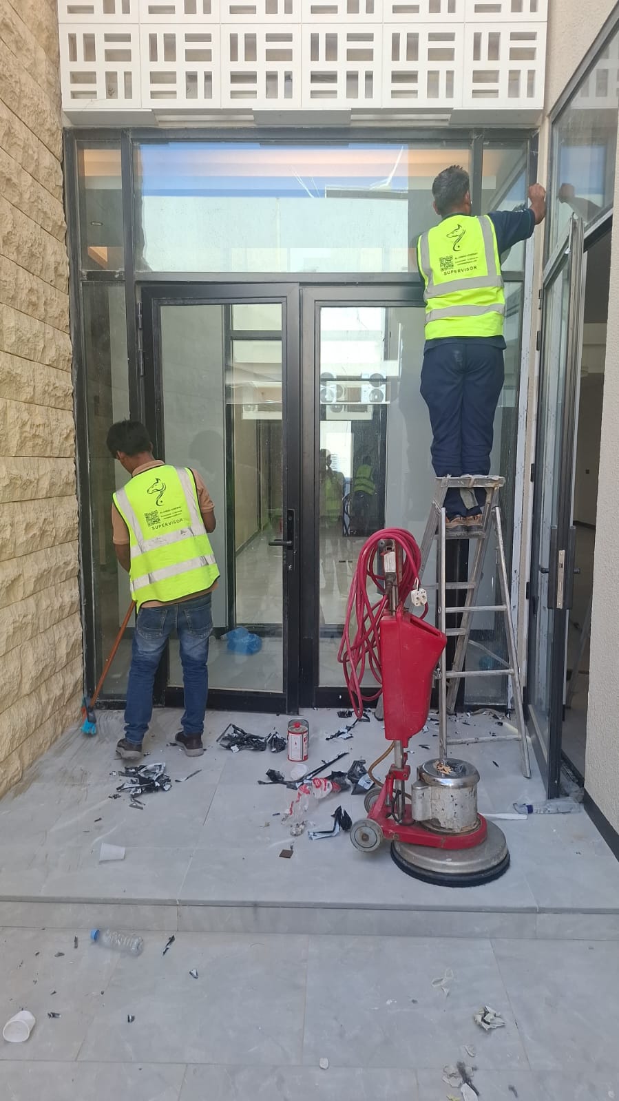 فريق حلول وتميز أثناء تنظيف مدخل زجاجي لمنزل جديد بالرياض