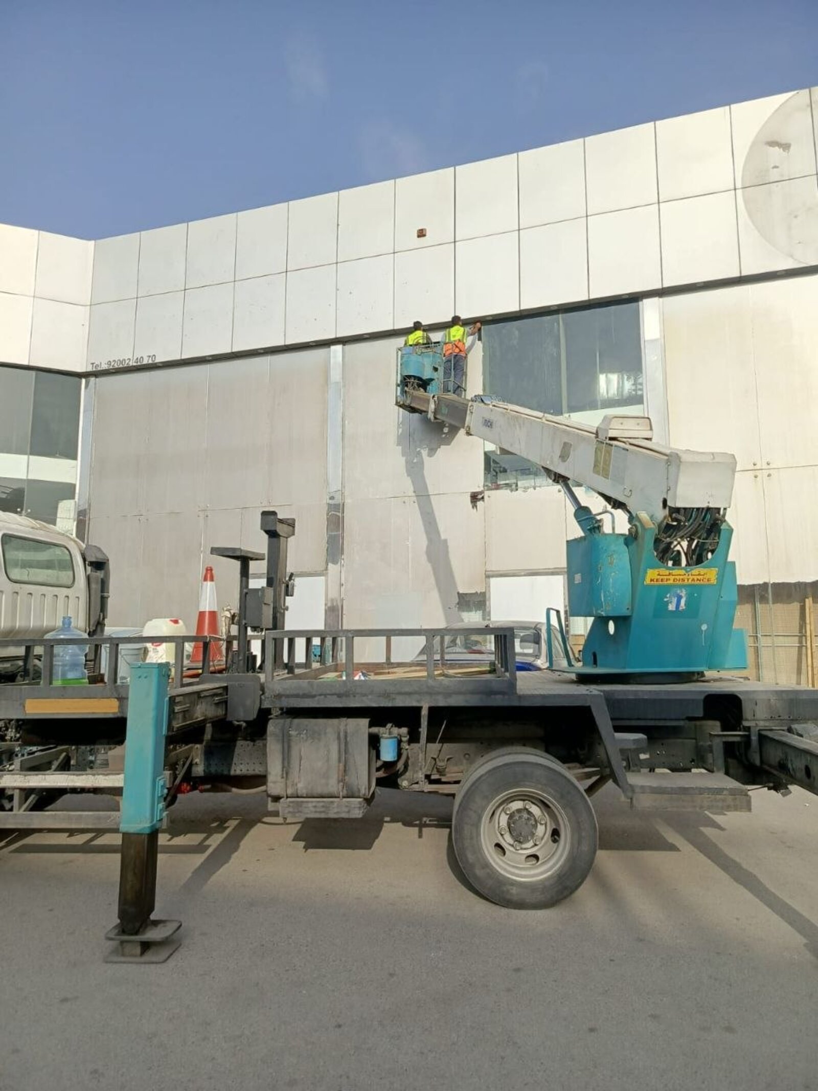 شركة تنظيف واجهات زجاجية بالرياض تزيل استيكرات قديمة من واجهة مبنى تجاري - حلول وتميز