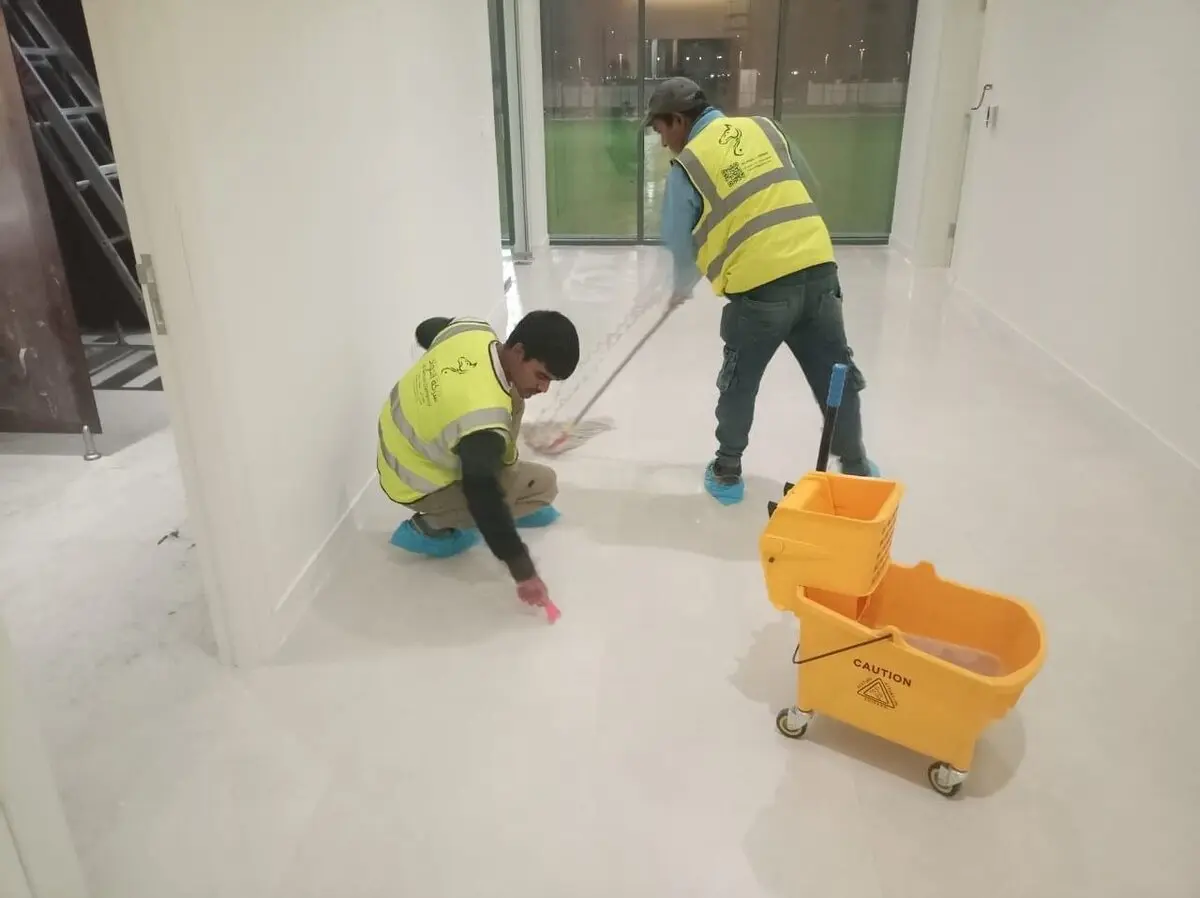 فريقان من شركة تنظيف محلات بحي الياسمين بالرياض ينظفان أرضية محل تجاري بعد التشطيب