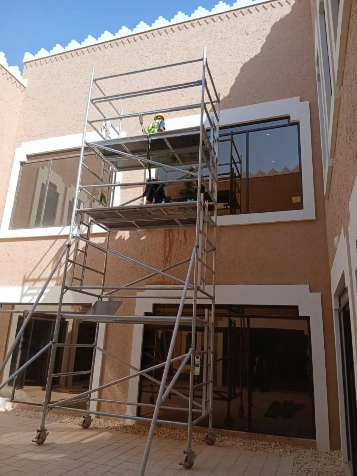 فريق شركة تنظيف واجهات بحي الدرعية ينظف نوافذ فيلا بطراز نجدي باستخدام برج سقالة