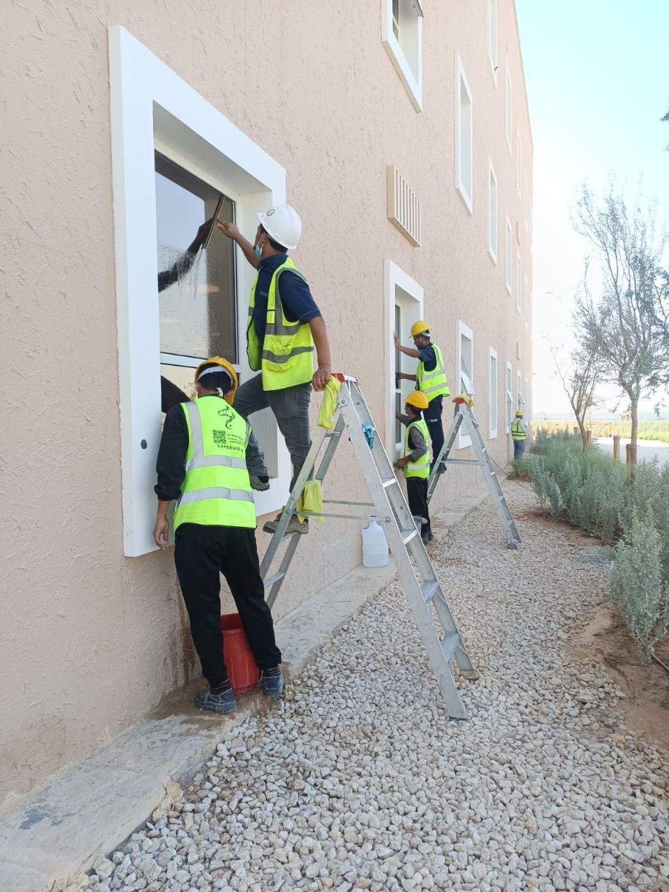 فريق حلول وتميز أثناء تنظيف نوافذ فيلا زجاجية بالرياض